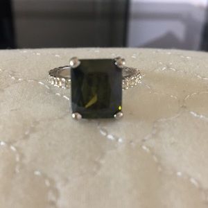 Ring with large green center stone. Diamond band